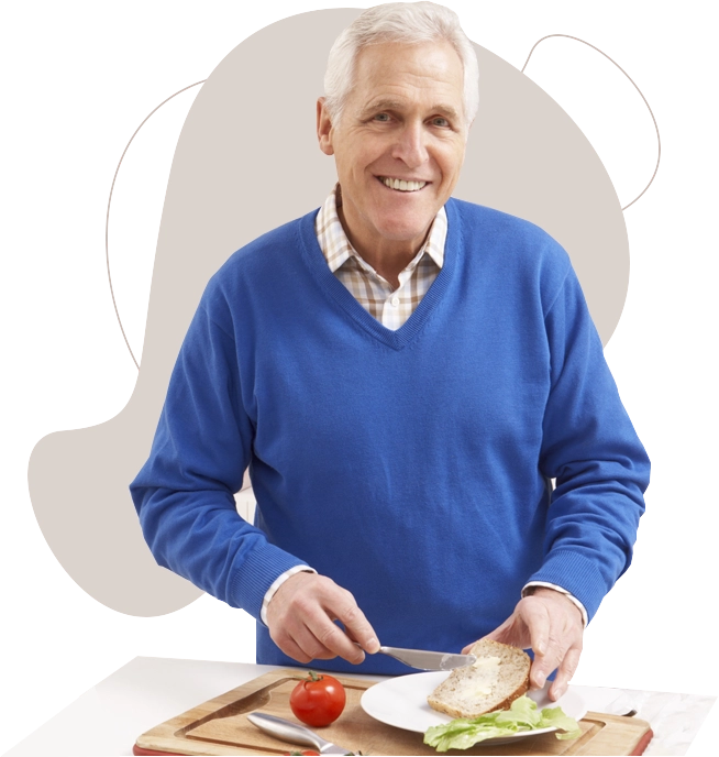 Senior aged man making a sandwich.